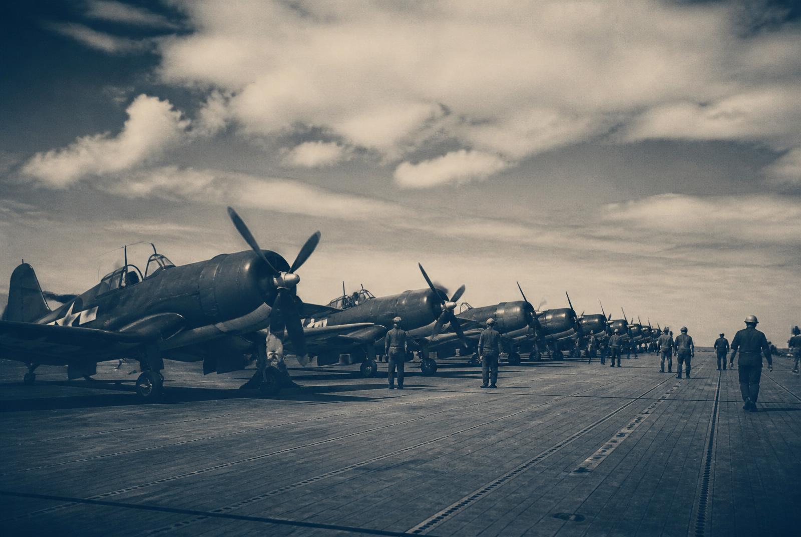 Rows of propeller fighters parked on a carrier deck